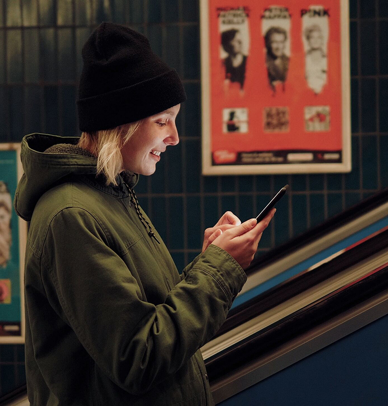 woman using phone on escalator