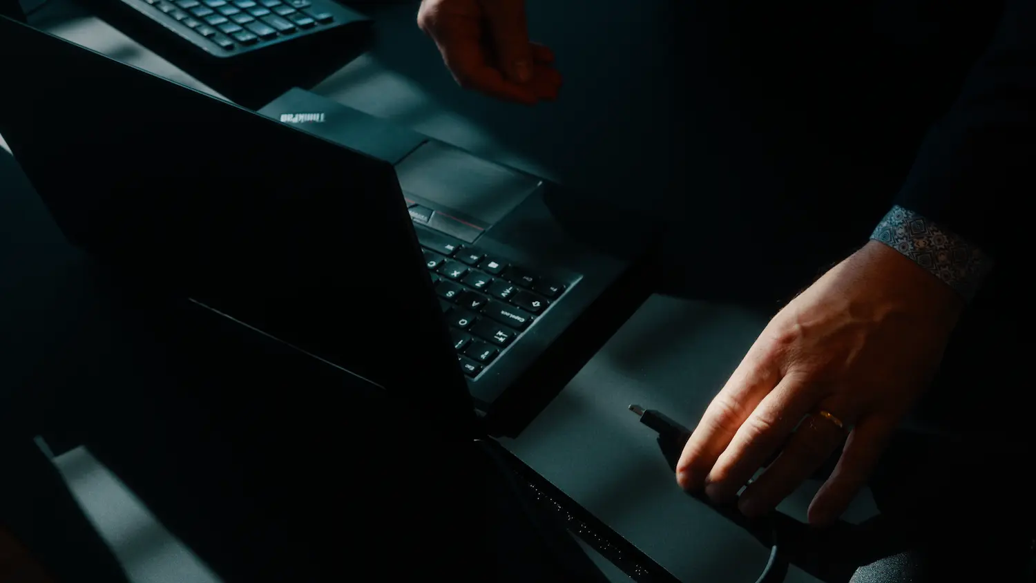 Laptop på et mørkt skrivebord